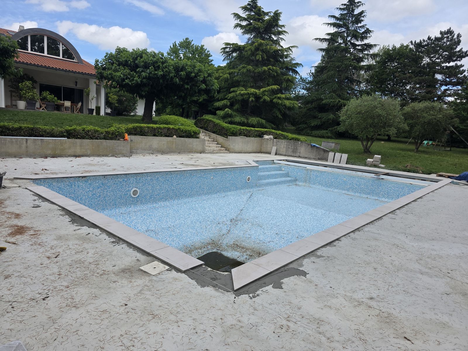 Chantier de piscine avec margelles et plage béton en cours